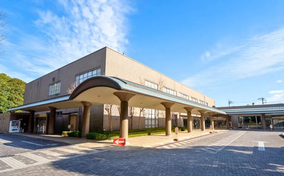 相模原市営斎場の外観。柱の並ぶ大きな屋根の車寄せがある入口